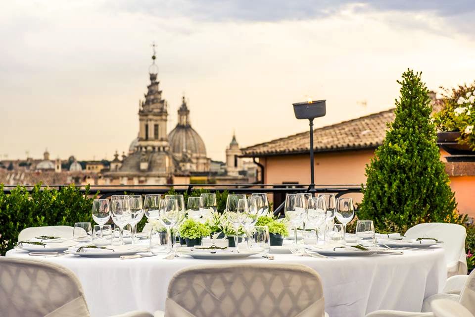 An elegant lunch table set on the roofterrace of luxury wedding hotel with stunning view over Rome