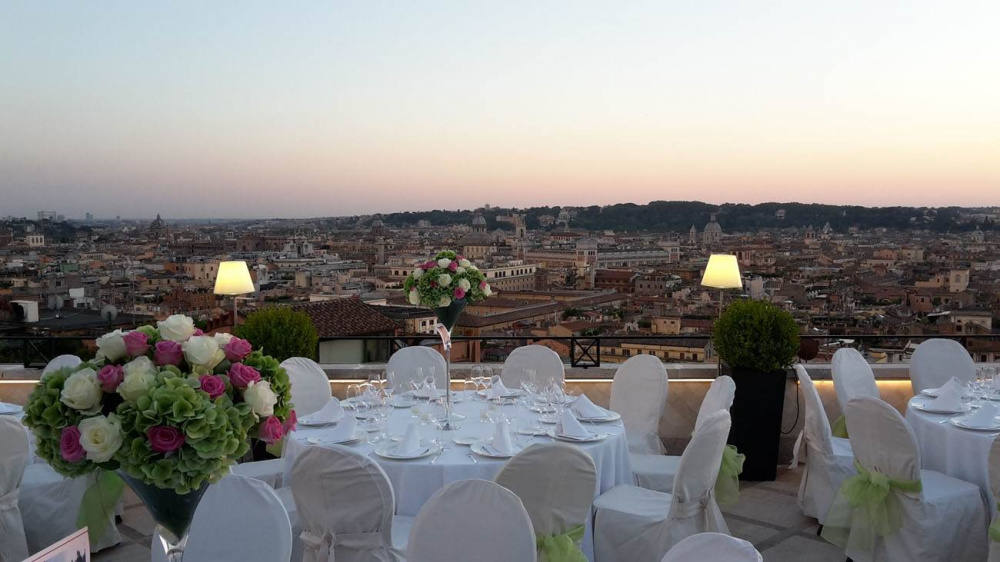 Wedding dinner set-up ,elegant tables and coloured fresh flowers con the tables in panoramic terrace