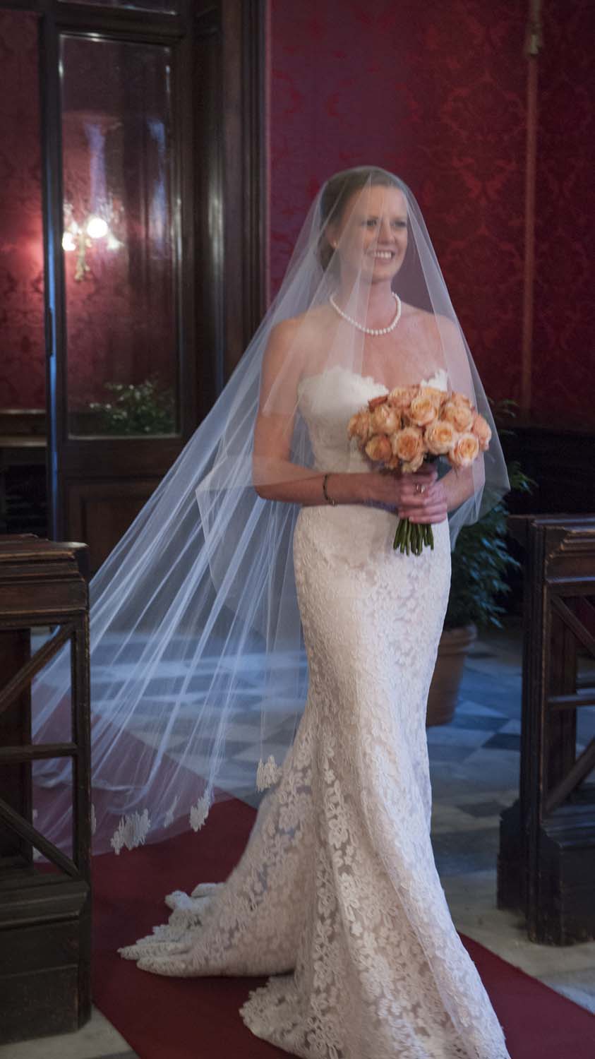 Bridal entrance with white dress and peach color bouquet