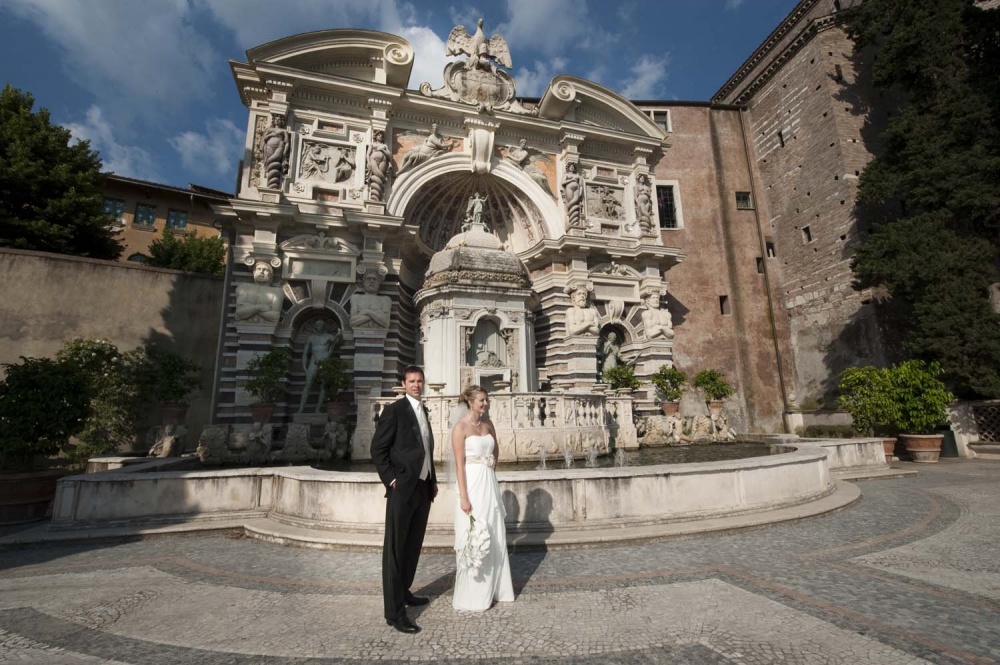 Bride and groom walking in the garden of Villa d'Este in Tivoli on their wedding date