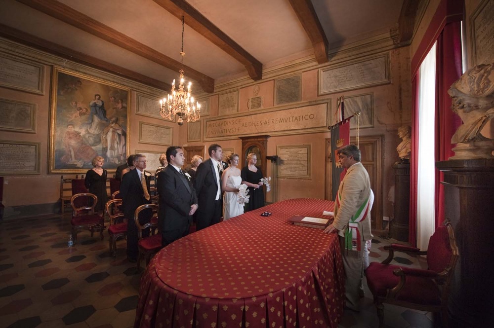 View of the ceremony hall in Tivoli with a red table and paintings during wedding civil ceremony