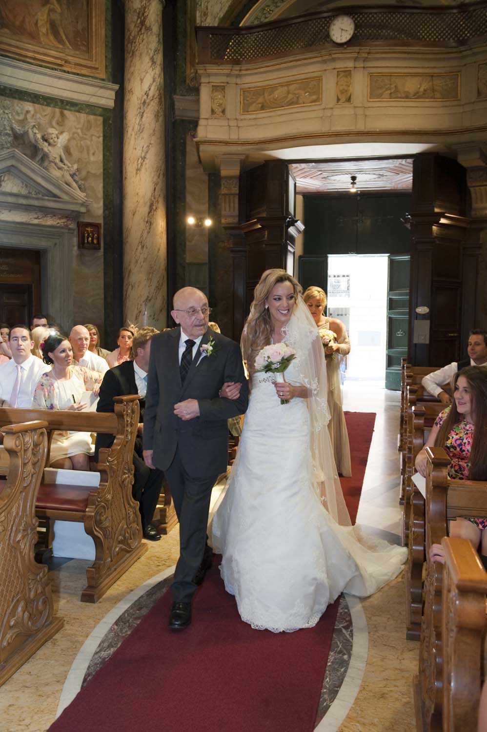 Bride and her father along the aisle of a Church in Vatican, Rome