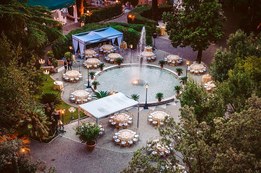 Aerial view wedding set-up with elegant round tables in the palace's verdant gardens in Rome