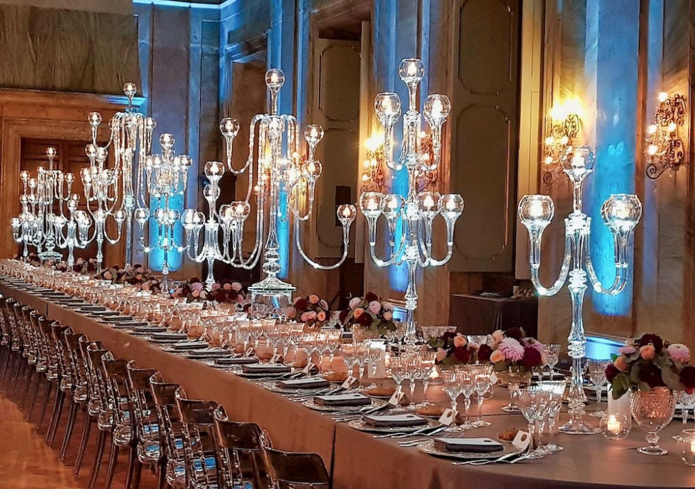 An extremely romantic wedding dinner set-up in shades of red and pink and elegant glass candelabras