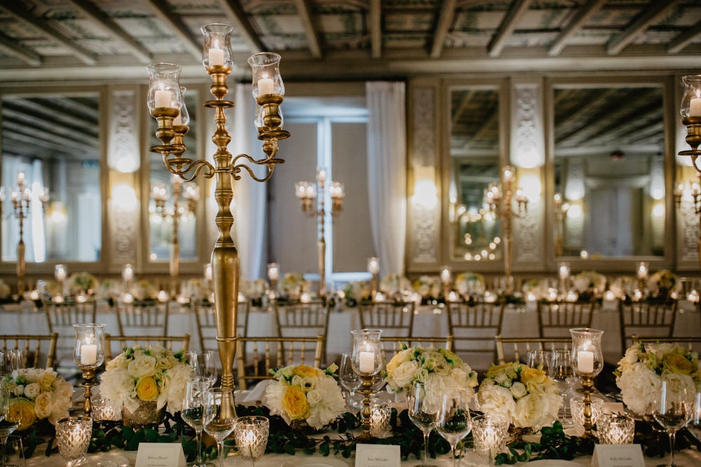 Wedding decor with gold candelabras, ivory flowers and candles