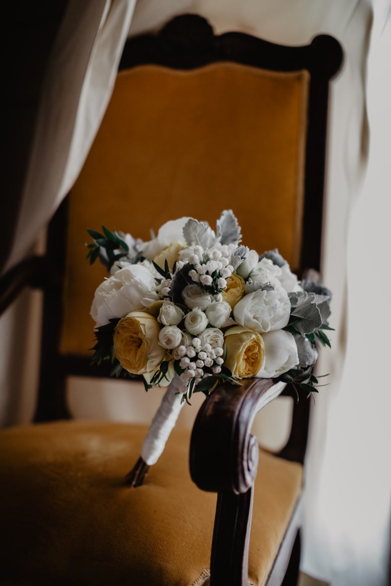 White and yellow bridal bouquet on an orange armchair