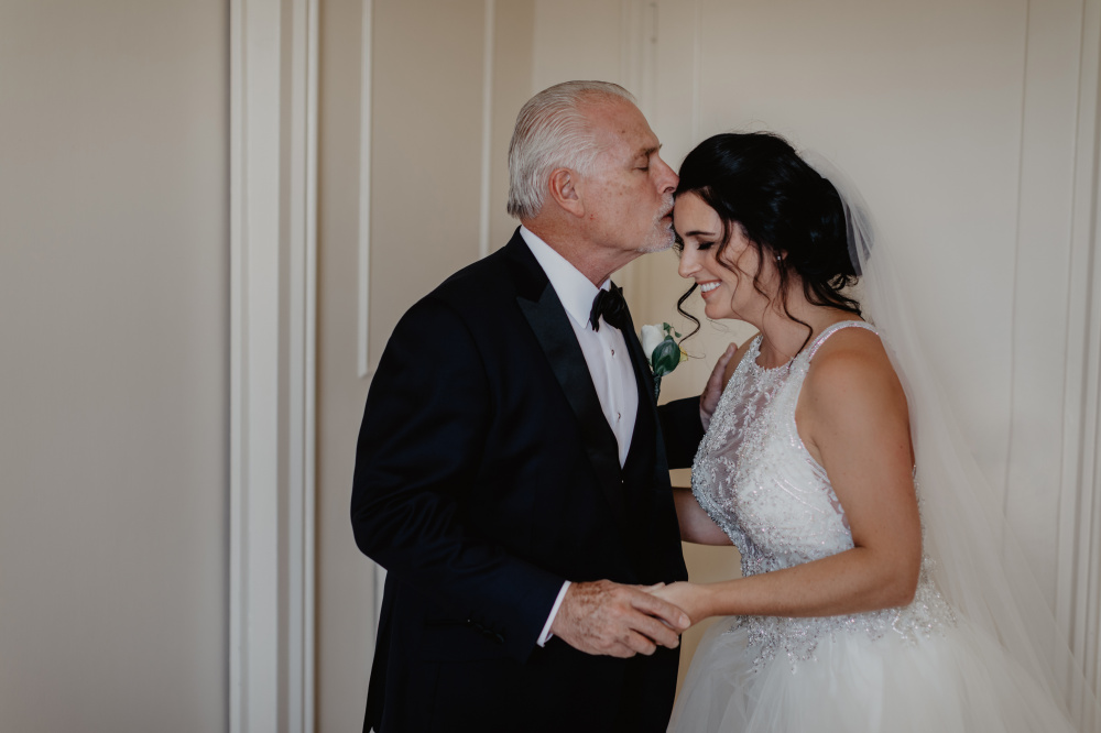 Father of the bride kisses his daugther