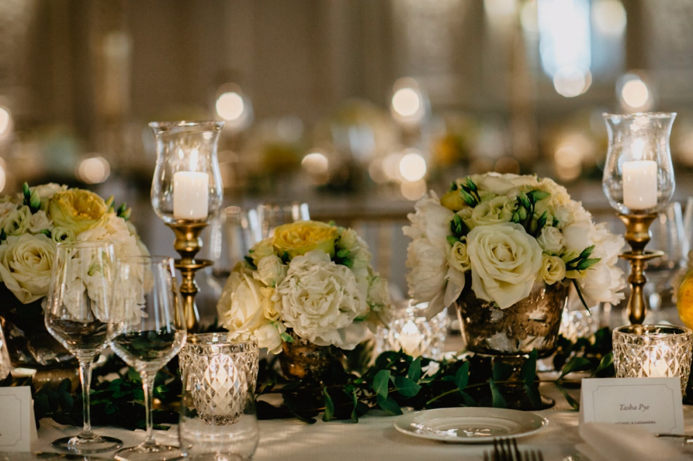 White and yellow flowers with candles as table decor