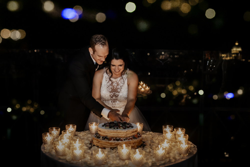 Bride and groom cutting the wedding cake in Rome