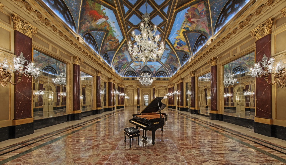 Baroque style ballroom of a luxury hotel in Rome with piano and chandelier